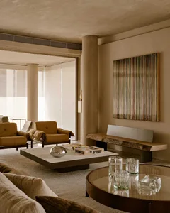 A modern living room featuring concrete, glass, and wood materials.