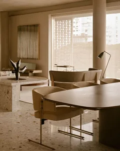 A modern office space featuring concrete surfaces and leather furniture.