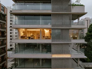 A modern residential apartment building with concrete and glass exterior.