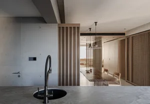 A modern residential kitchen features a concrete countertop and wooden cabinets.