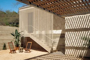 A minimalist exterior design featuring wooden elements and a pergola.
