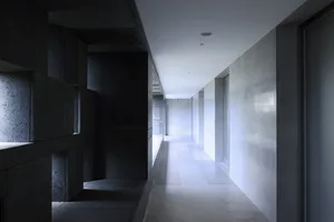 A modern architectural corridor with concrete walls and floors.