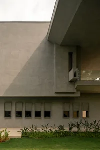 A modern house with a concrete exterior and landscaped garden.