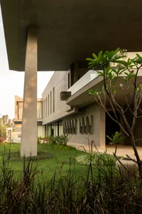 Modern house with concrete exterior and green landscaping.