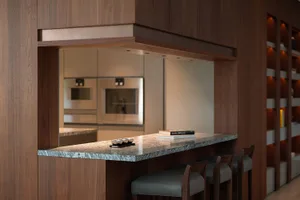 Modern kitchen featuring a marble bar counter with stools and a sleek interior design.