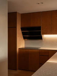 A modern kitchen with wooden cabinets and a sleek, minimalist design.