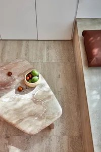 A modern living room featuring a marble coffee table with a bowl of fruits.
