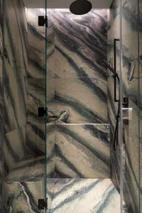 Modern bathroom shower with marble tiles and black fixtures