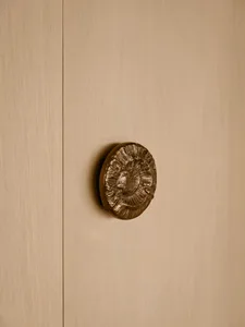 A modern minimalist brown door handle with a textured design