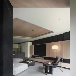 A modern minimalist living room with marble and wooden finishes.