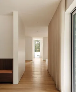 Modern study with light wood flooring and large windows