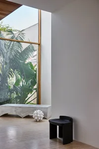 Minimalist architectural space with concrete window and garden view, showcasing industrial and natural elements.