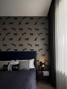 A modern minimalist bedroom with textured fabric bedding and leopard print wallpaper