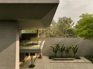 Contemporary structure with minimalist design, featuring concrete materials and greenery.