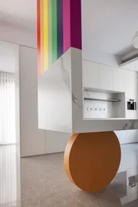 A modern, open-concept kitchen with colorful stripes on the wall and a floating island counter.