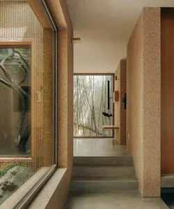 A minimalist interior featuring concrete and glass materials.