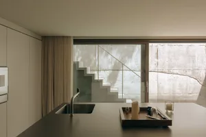 A modern, minimalist residential kitchen featuring concrete elements.