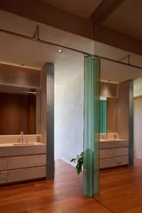 Modern bathroom with marble surfaces and a green curtain.