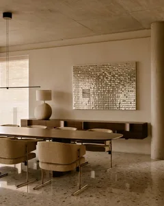 Modern dining room featuring a metallic art piece and wooden dining table.