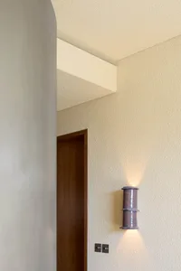 A modern interior design featuring a concrete wall lamp.