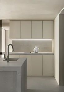 Modern minimalist kitchen with concrete countertops, cabinets, and backsplash.