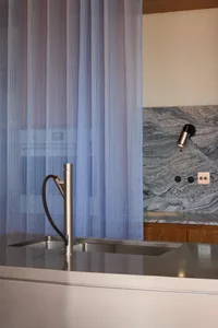 Modern kitchen featuring stainless steel appliances, granite countertops, and a table lamp.