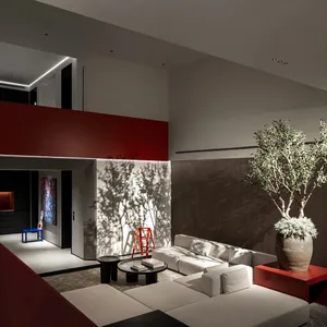 Modern living room featuring red concrete walls, white leather sofas, and a large tree in a vase.