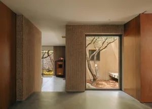 A minimalist residential interior scene with concrete walls and floors.