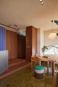 A modern residential dining room featuring concrete and wooden elements.