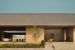 Modern minimalist architectural exterior with concrete walls and clay-tile roofing.
