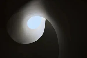 Circular staircase with a light source at the top, minimalistic design