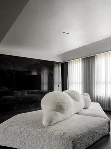 A minimalist living room with textured fabrics and marble accents.