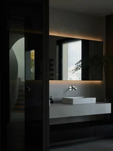 A modern bathroom featuring sleek, minimalist design with concrete elements and artistic installations.