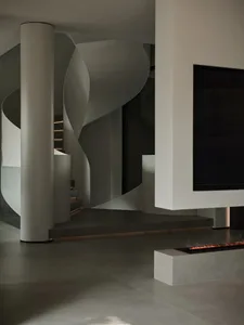 A modern interior space featuring concrete flooring and glass elements.