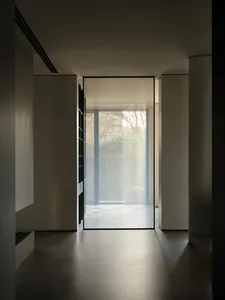 Modern interior with a glass panel door in a hallway.