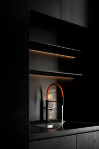 A modern kitchen design featuring dark wood cabinetry and a sleek, contemporary faucet.