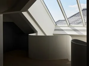 Modern loft interior with white concrete walls and skylight