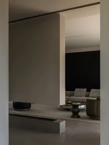 A modern living room with concrete flooring and minimalist furniture.