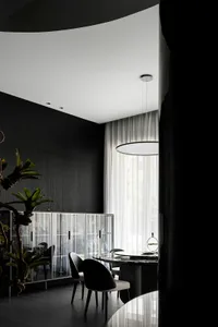 Modern minimalist dining room featuring glass, marble, and metal elements.