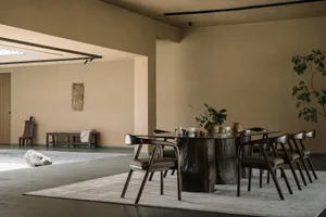 Modern dining room with wooden table and chairs, minimalist decor, and natural light.
