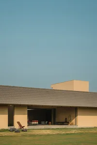 A modern residential exterior with clay tile roofing and concrete columns.