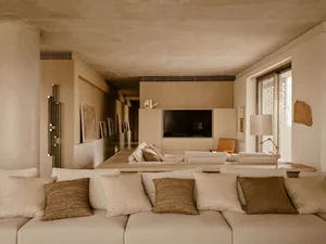 Modern, minimalist living room with neutral textiles, wooden furniture, and sleek design features.