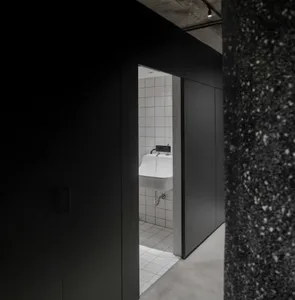 Bathroom with industrial design featuring concrete flooring and white tiled walls