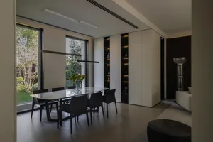 Modern dining room featuring a marble table and black chairs.
