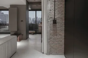 Modern apartment interior featuring exposed brick walls and concrete flooring.