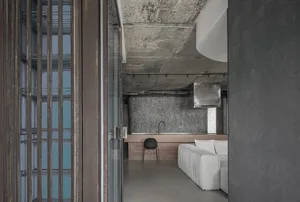 Modern industrial residential kitchen featuring concrete and glass materials.