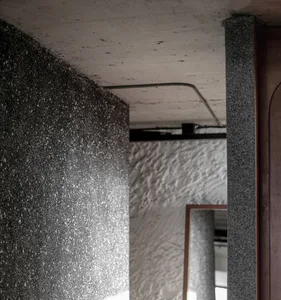 An interior space with modern, textured concrete walls and a column.