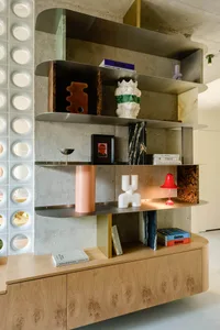 Modern interior design featuring metal shelves on a concrete background.