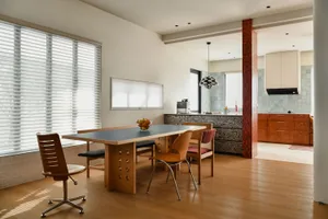 Modern residential kitchen featuring a concrete countertop and wooden furniture.