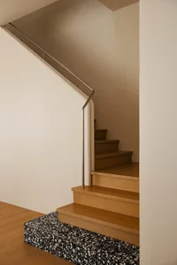 Modern staircase with wooden steps and a floor tile design